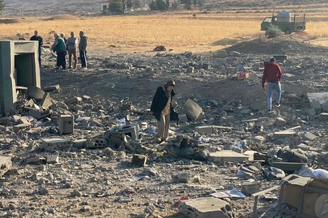 People inspect the damage at the site of an Israeli airstrike