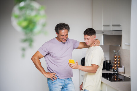 Un figlio mostra al padre lo smartphone foto iStock.