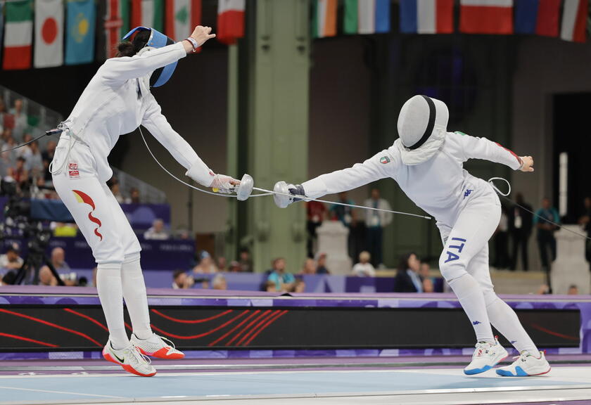 Yien Sun (L) de China en acción contra Giulia Rizzi de Italia, en esgrima