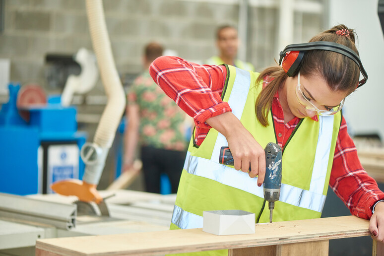 Una giovane donna lavora sul legno foto iStock. - RIPRODUZIONE RISERVATA