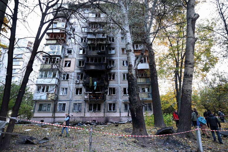 Local residents walk around their multi-story building damaged by the explosion of a strike © ANSA/AFP