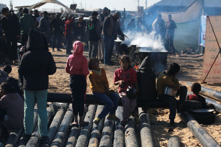 Gaza, a Khan Younis in fila per una porzione di cibo © ANSA/AFP