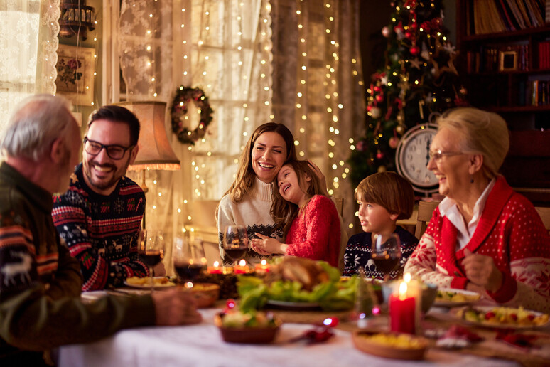 La famiglia a tavola durante il Natale foto iStock. - RIPRODUZIONE RISERVATA