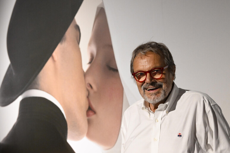 Oliviero Toscani con il celebre scatto del bacio tra un prete e una suora - RIPRODUZIONE RISERVATA