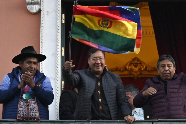 Luis Arce hasteia bandeira na sacada do Palácio do Governo, em La Paz © ANSA/AFP