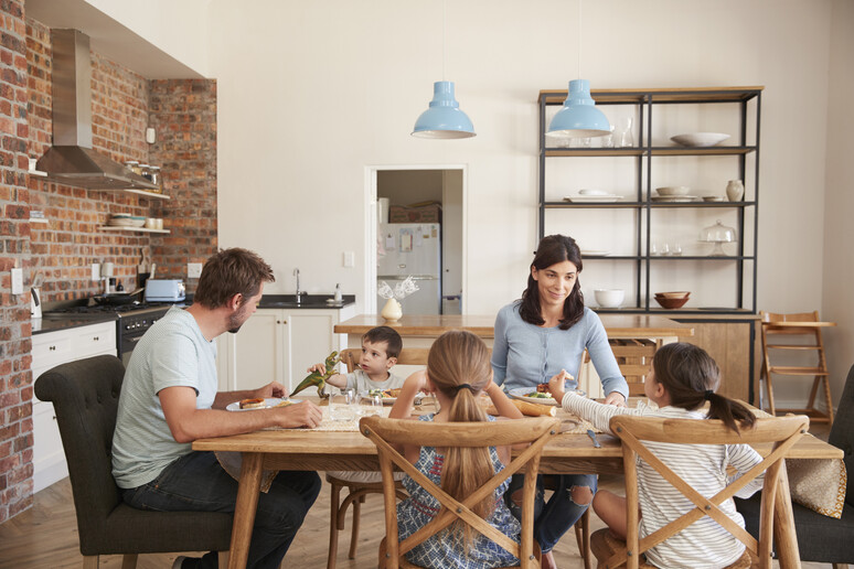 Una famiglia riunita a tavola foto iStock. - RIPRODUZIONE RISERVATA