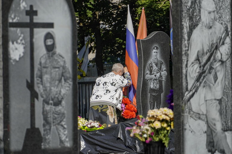 Mulher diante de túmulo de oficial russo no cemitério de Kursk © ANSA/EPA