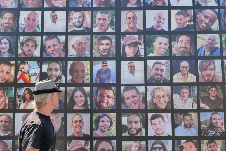 Homem observa painel com fotos de reféns sequestrados pelo Hamas em Jerusalém © ANSA/EPA